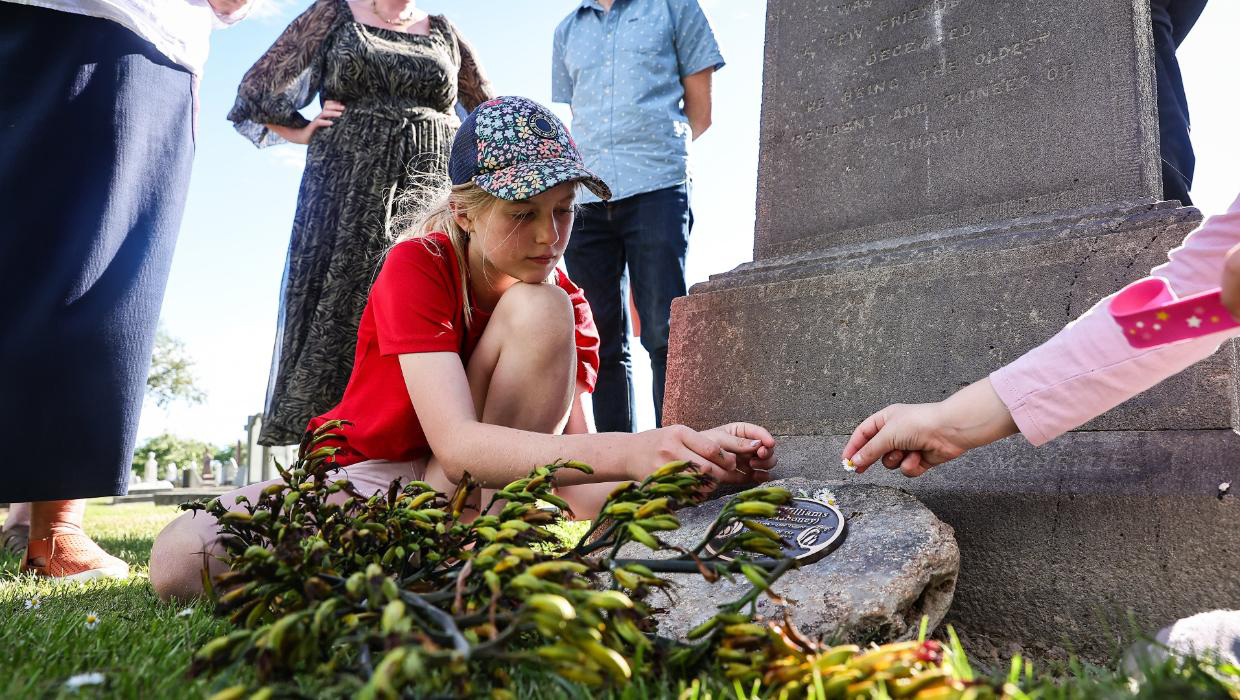 Medinella Fauth and her sister Annabelle Fauth decorate Ann Williams memorial at Timaru Cemetery with flowers at its unveiling this week