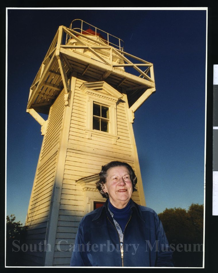 Ginny Talbot posing in front of a Timaru's Blackett lighthouse, dated 29 June 1999. John Bisset, Timaru Herald Photographer. South Canterbury Museum 2012/186.9674